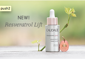 A flower and pear shown with Caudalie resveratrol lift product.
